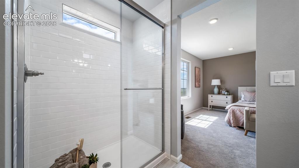 Image 36 of 39: Shower enclosure featuring white subway tile surround, clear glass door, an