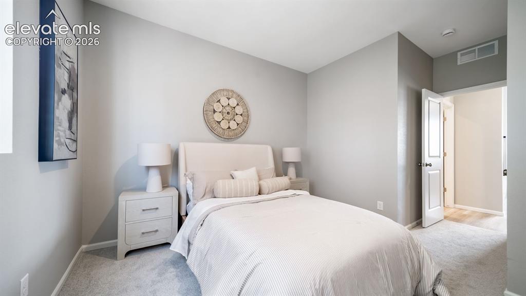 Image 4 of 39: Carpeted room featuring light gray walls and a white paneled door
Photos o