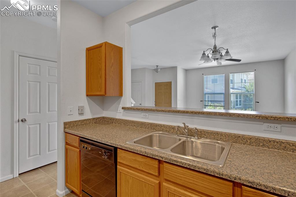 Image 10 of 24: Kitchen featuring dishwasher, light tile patterned flooring, a chandelier, 