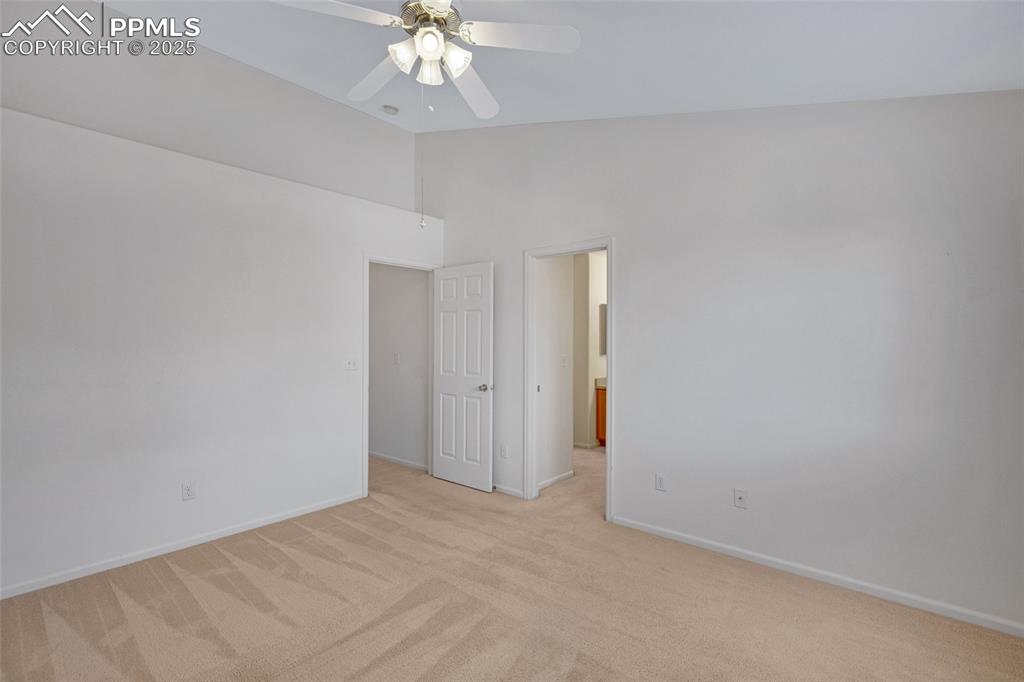 Image 16 of 24: Empty room featuring light colored carpet, a ceiling fan, and high vaulted 