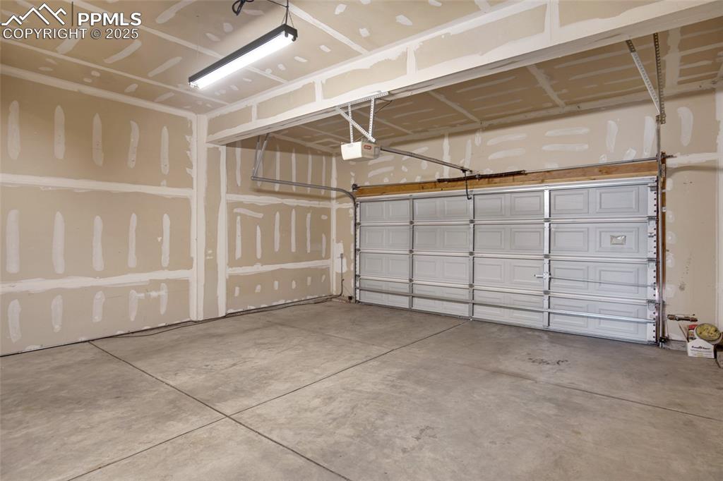 Image 21 of 24: Garage featuring a garage door opener