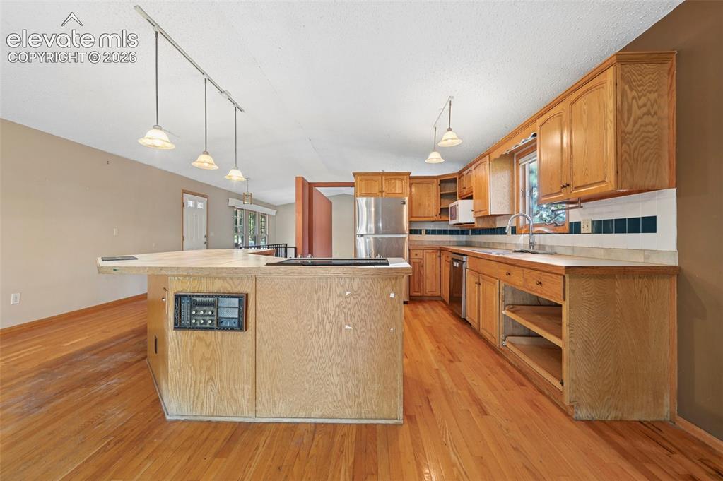 Image 10 of 47: Kitchen featuring wood-finish flooring, wood cabinetry, recessed lighting, 