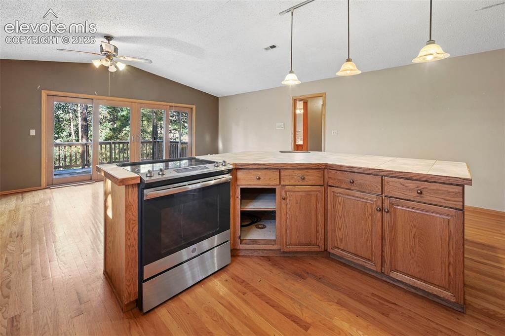 Image 11 of 47: Hardwood flooring, stainless steel range, built-in cabinetry, tile countert