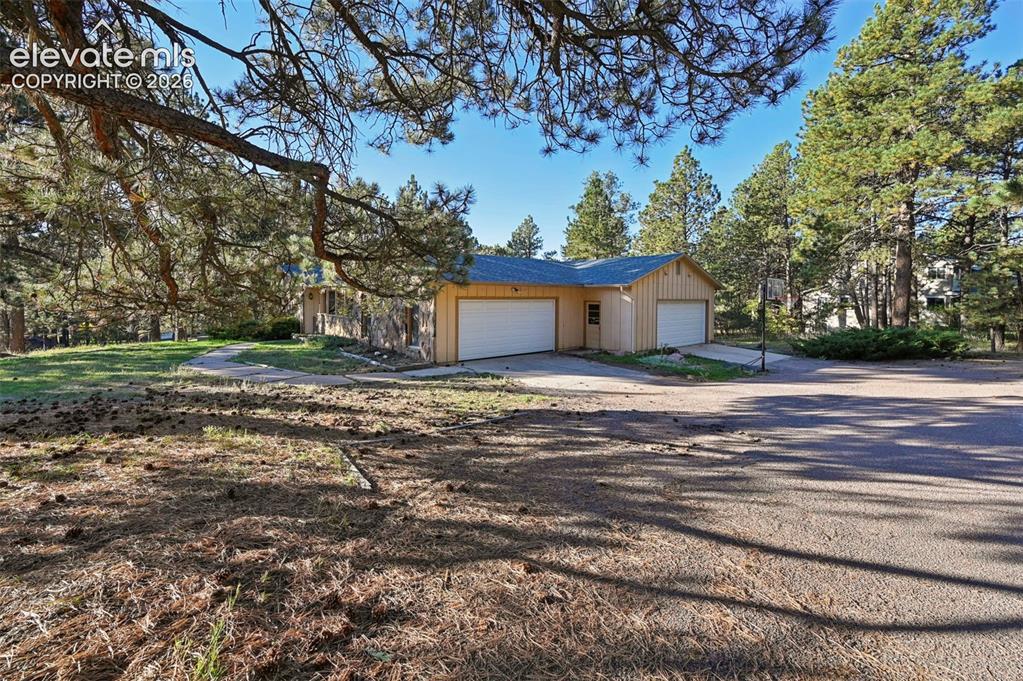 Image 2 of 47: Property exterior featuring a two-car garage, light-colored siding, and a p