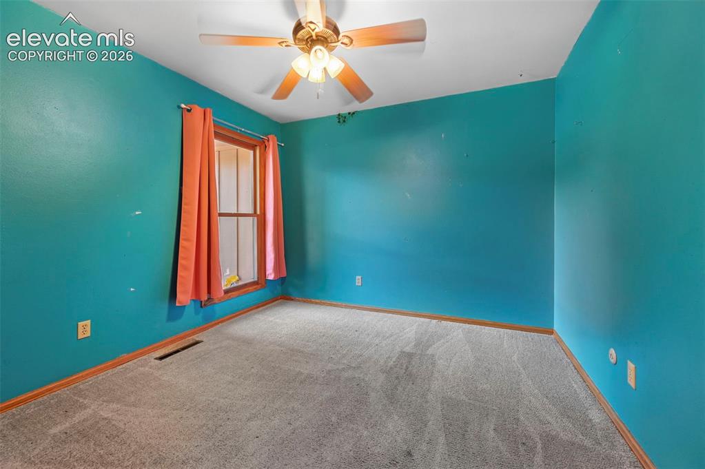 Image 27 of 47: Carpeted flooring, single window, and a ceiling fan with light fixture