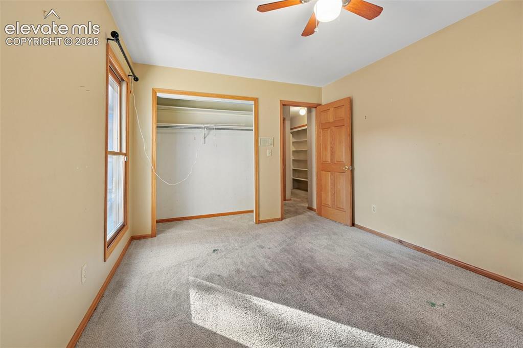 Image 30 of 47: Recessed closet with shelving, wood-paneled door, and wood-framed window