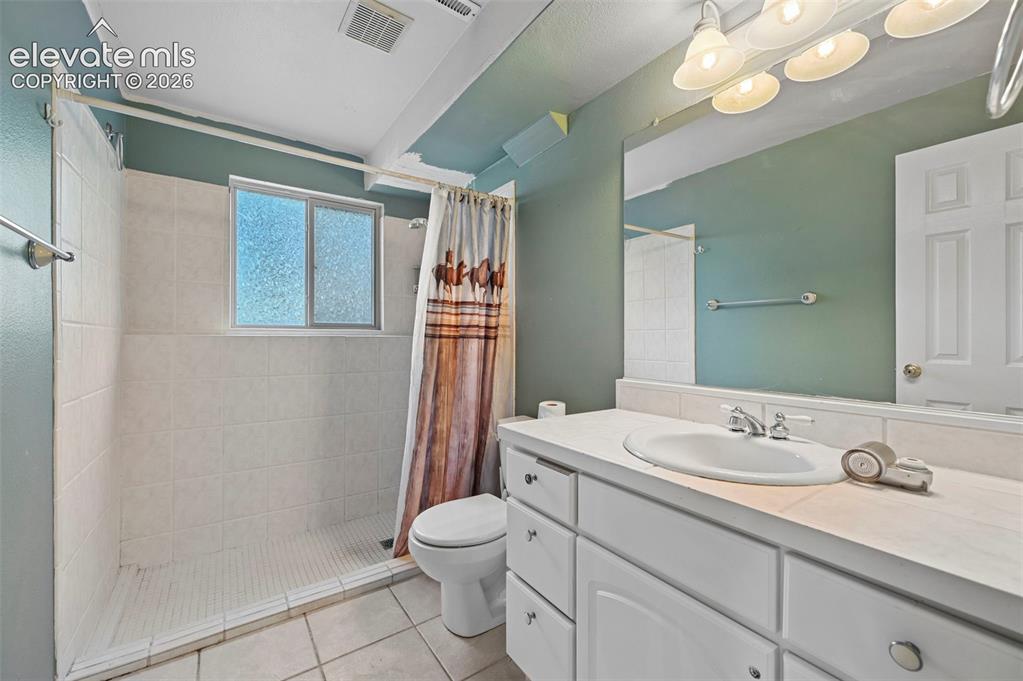 Image 37 of 47: Bathroom with white tile flooring, a walk-in shower featuring white tile wa