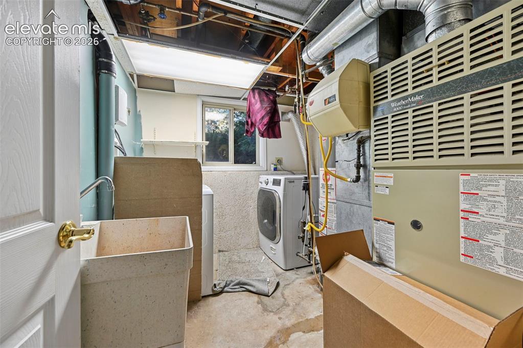 Image 47 of 47: Utility room featuring a laundry sink with a faucet, a window, exposed ceil