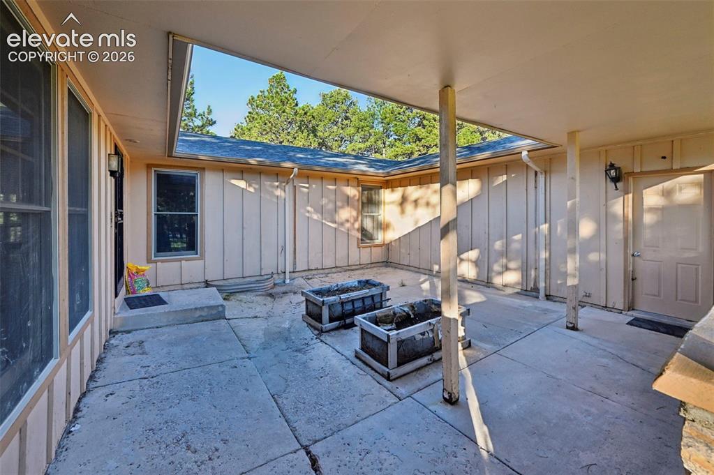 Image 7 of 47: Covered patio featuring concrete flooring and exterior wall sconces