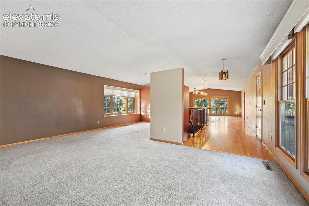 Image 9 of 47: Carpeted living area with a large bay window