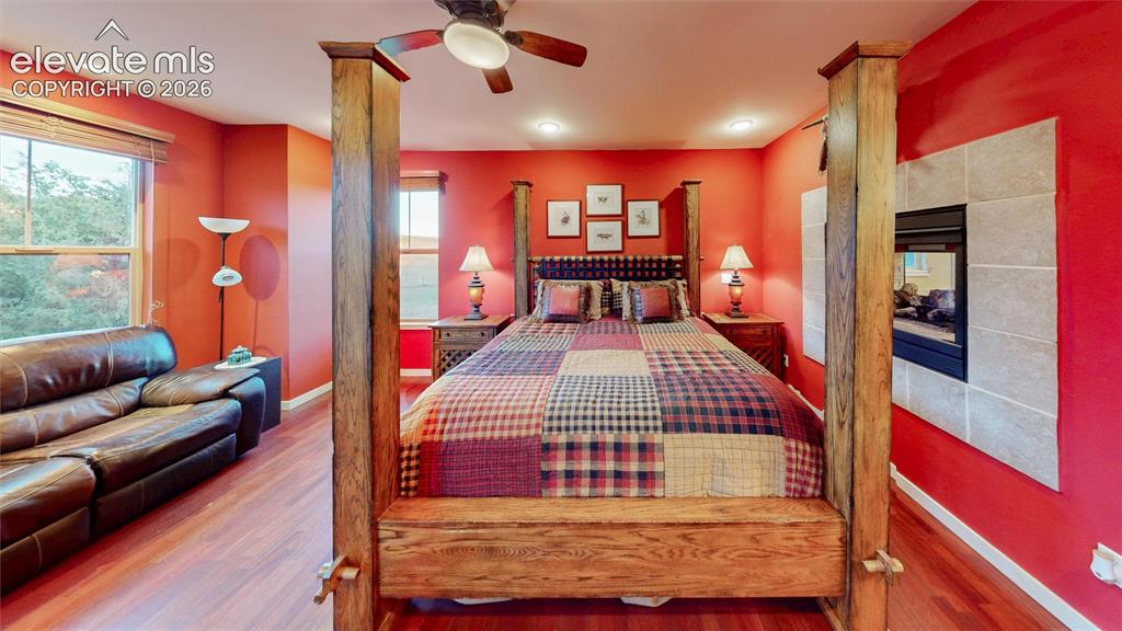 Image 26 of 44: Main floor primary bedroom with 3-sided fireplace.