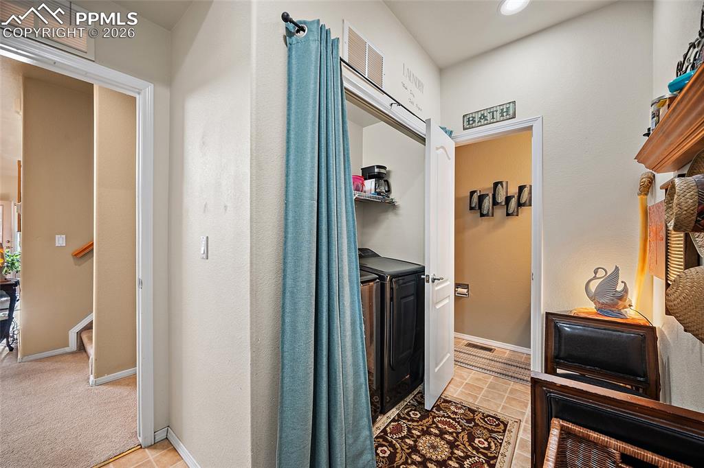 Image 18 of 49: Entry from garage sitting area to remove shoes, laundry and powder room. 