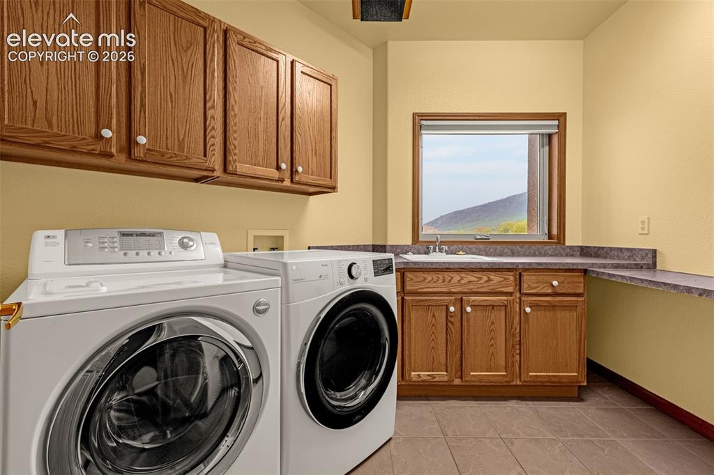 Image 39 of 43: Main level laundry room with sink, counters and window