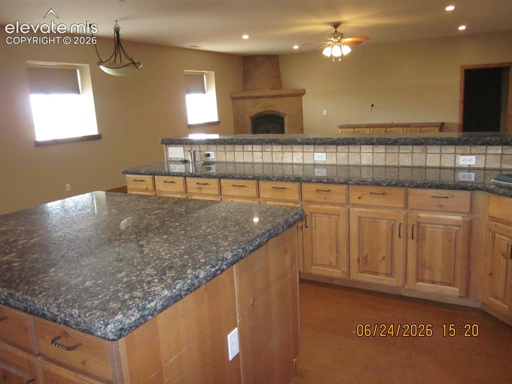 Image 13 of 34: Granite countertops surfaces, Island and stove top, microwave and over are