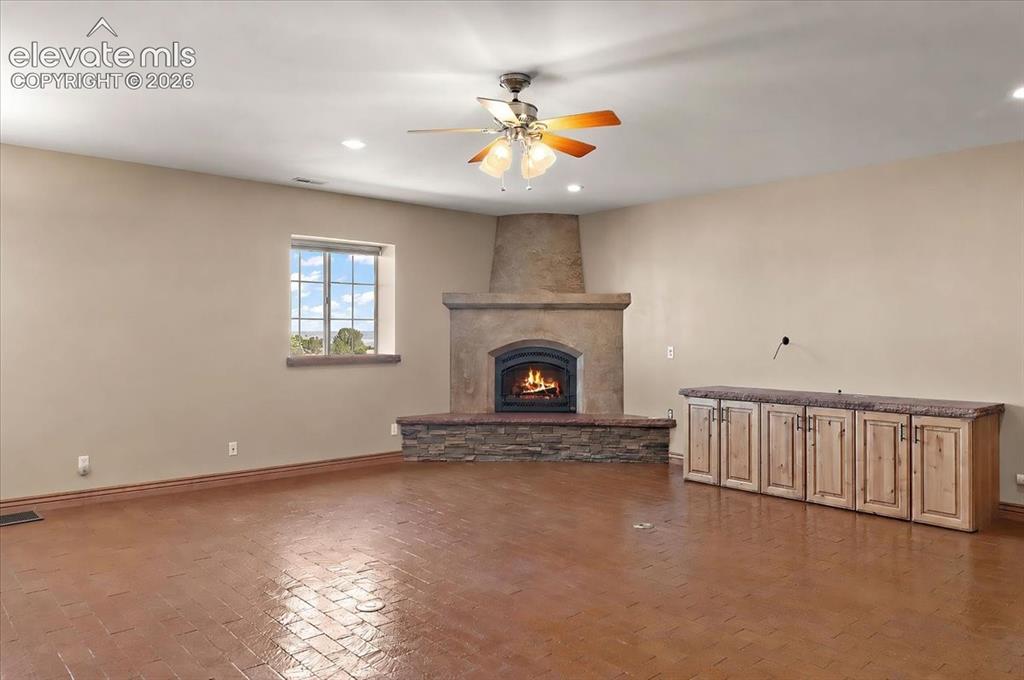 Image 13 of 50: Living room with brick floor, storage for entertainment equipment and a gas