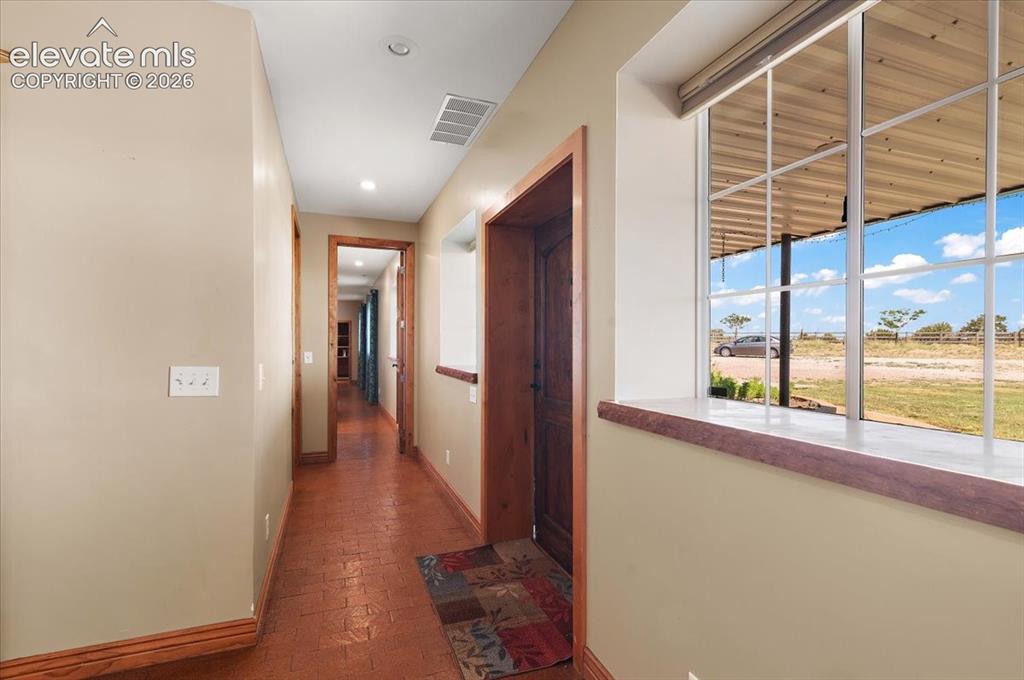 Image 17 of 50: Looking down the hallway toward the primary bedroom, laundry room, mud room