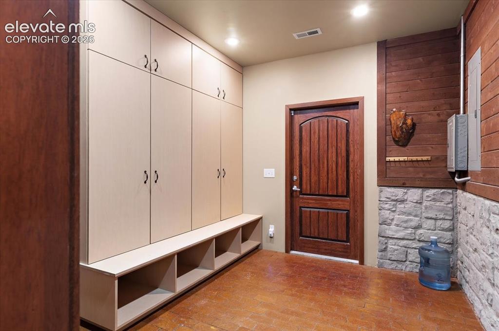 Image 18 of 50: Spacious 10 ft. X 11 ft. mudroom with lots of storage cabinets and seating