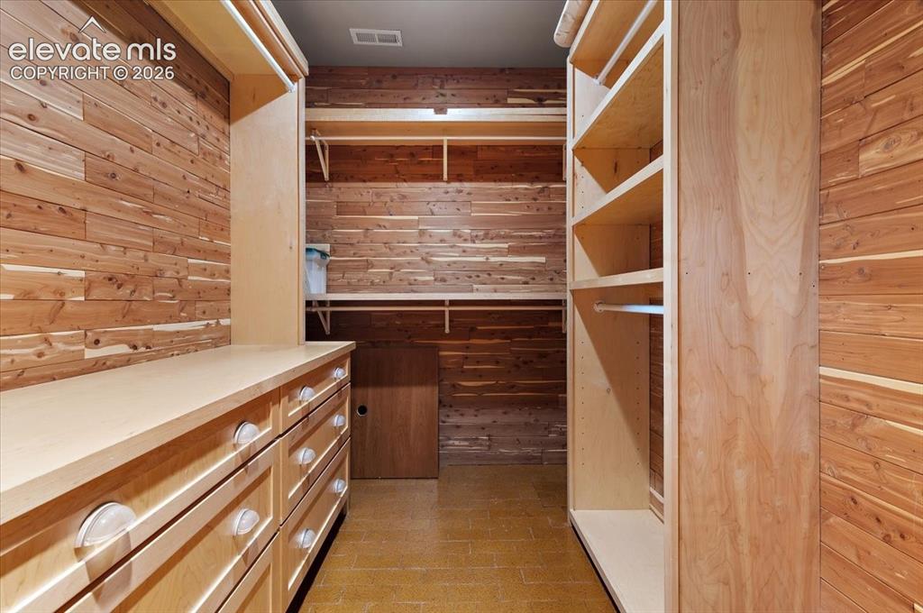 Image 22 of 50: Cedar lined primary bedroom closet.