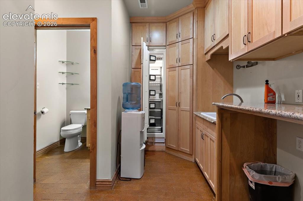 Image 27 of 50: 6 ft by 10 foot laundry room has utility sink, small built in Thermador fre