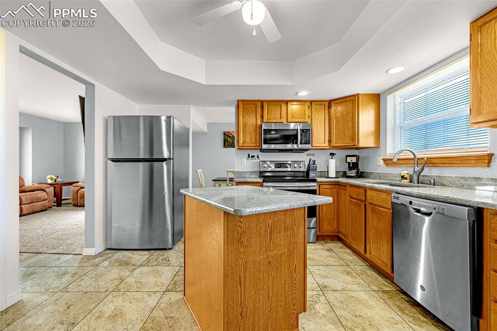 Image 10 of 42: Kitchen featuring stainless steel appliances, ceiling fan, a center island,