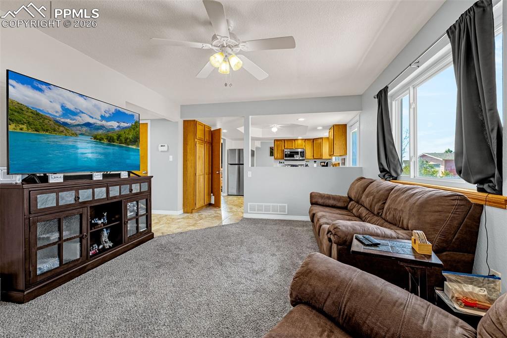 Image 12 of 42: Living area featuring a ceiling fan, light carpet, and recessed lighting