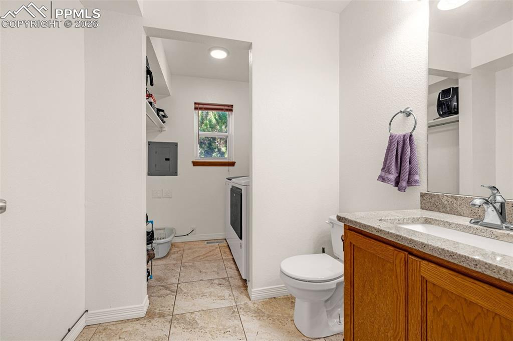 Image 13 of 42: Bathroom with vanity, electric panel, and light tile patterned floors