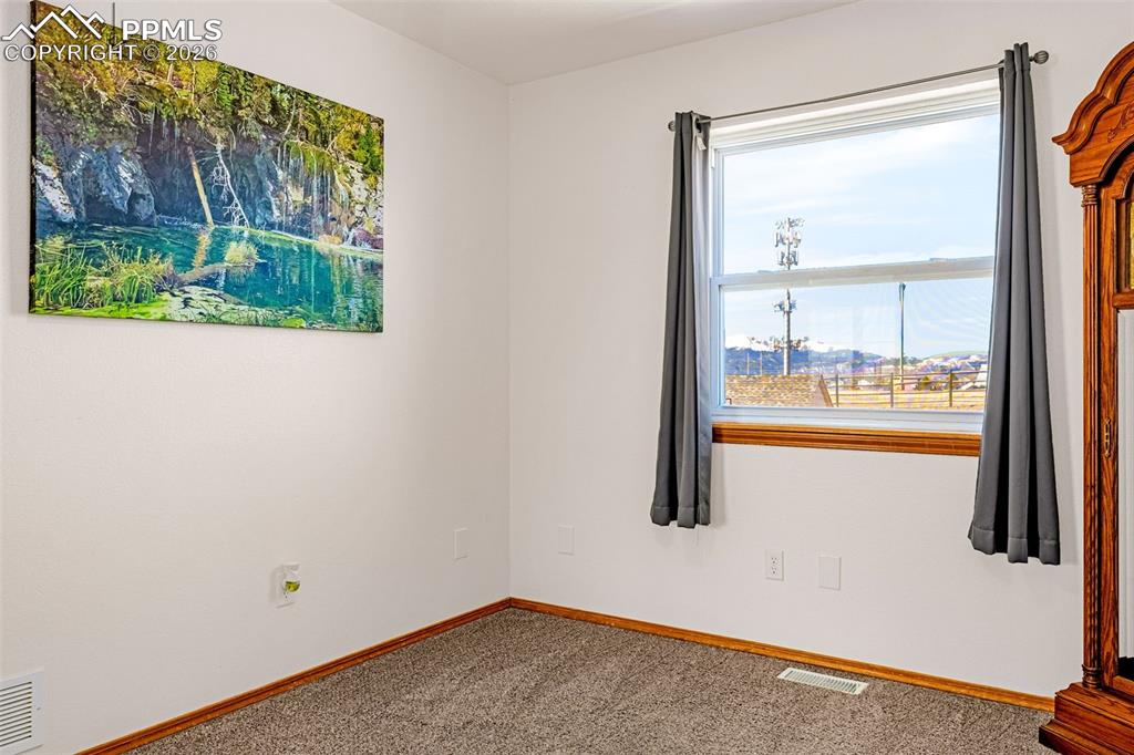 Image 15 of 42: Spare room featuring carpet and baseboards
