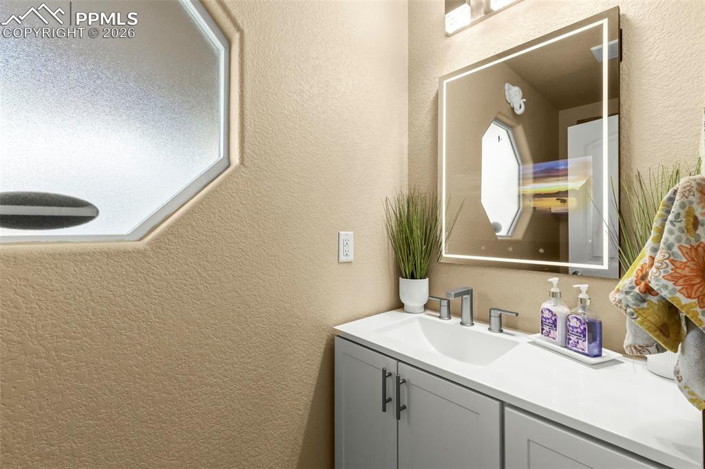 Image 19 of 50: Living area featuring light wood finished floors and a ceiling fan