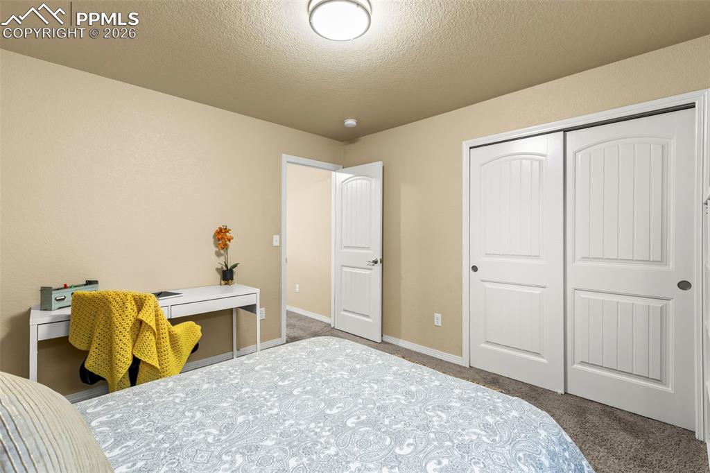 Image 23 of 50: Kitchen with stainless steel appliances, light stone countertops, white cab