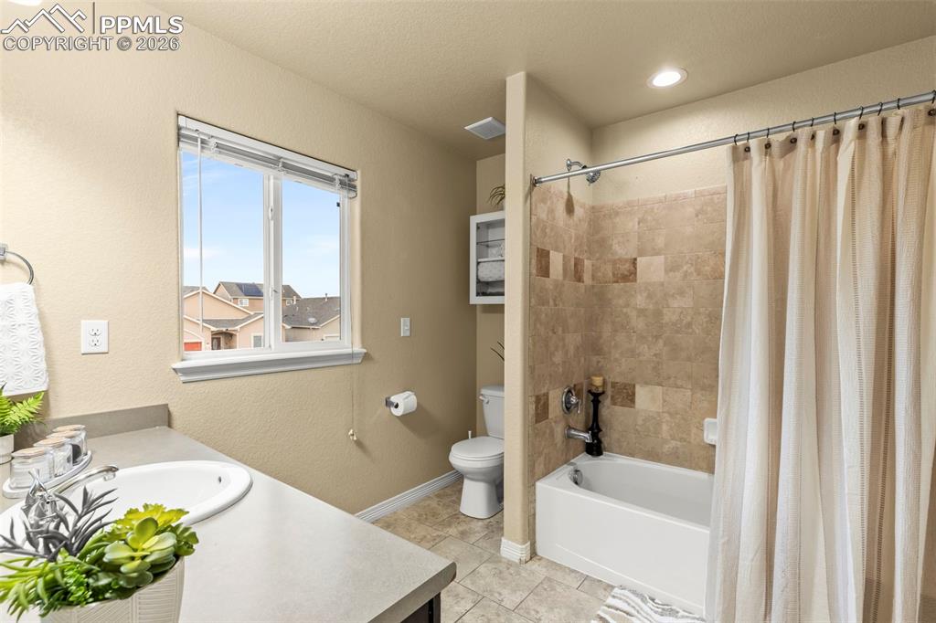 Image 24 of 50: Kitchen featuring stainless steel appliances, white cabinetry, light stone 