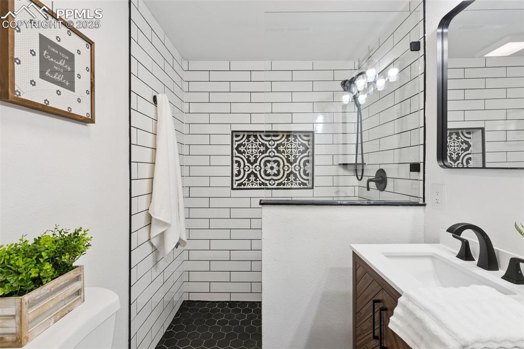 Image 27 of 38: Bathroom featuring vanity and a tile shower