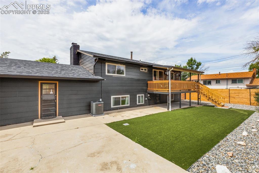Image 34 of 38: Back of property with stairs, a patio, a deck, a chimney, and a shingled ro