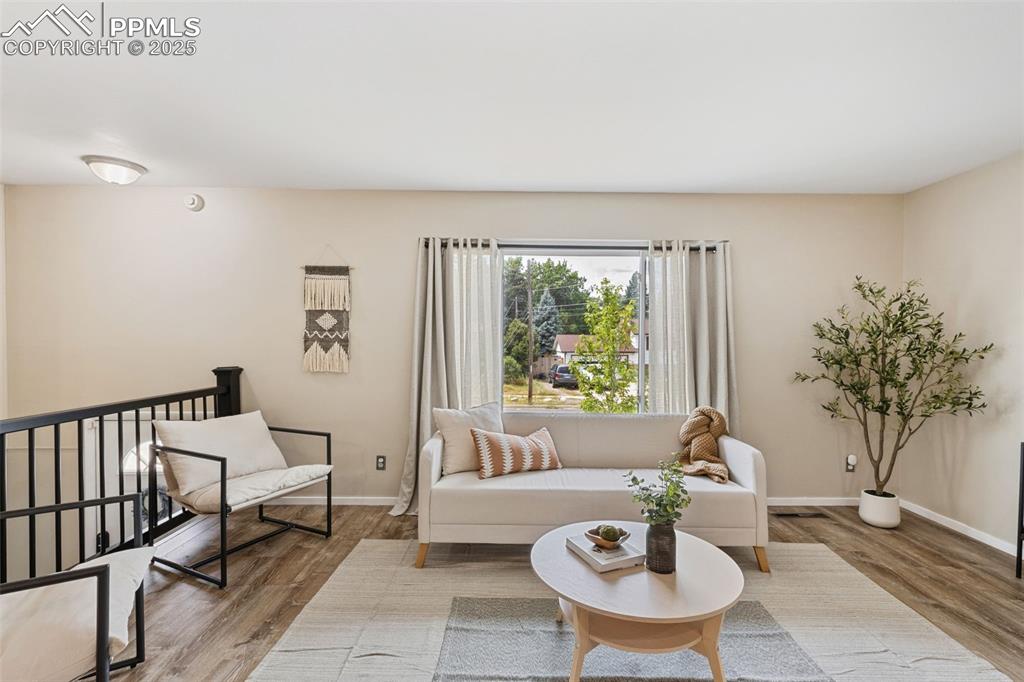 Image 6 of 38: Living area with wood finished floors and baseboards