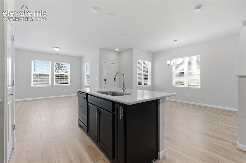 Image 15 of 42: Kitchen island with a stainless steel sink, gooseneck faucet, and quartz co