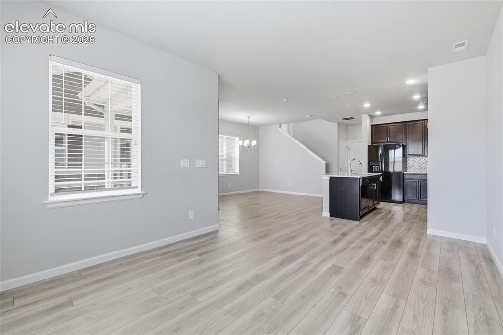 Image 16 of 42: Open-concept living space with light wood-finish flooring, recessed lightin