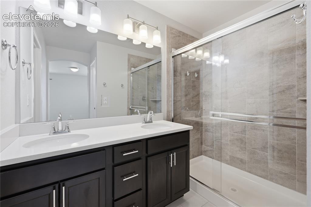 Image 24 of 42: Primary Bathroom featuring a spacious double vanity with dark wood cabinetr