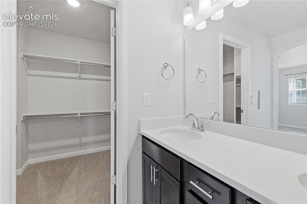 Image 25 of 42: Bathroom vanity featuring a white countertop with integrated sink, dark woo