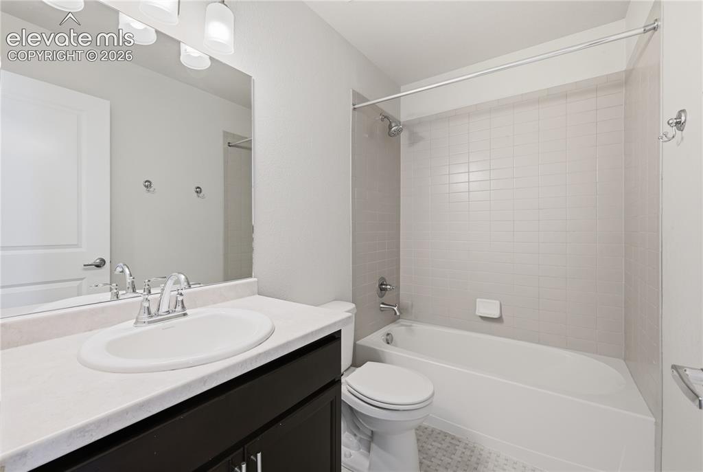 Image 31 of 42: Bathroom featuring a dark wood-finish vanity with a light-colored counterto