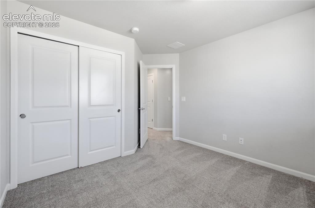 Image 32 of 42: Room featuring neutral gray carpeting and light gray wall paint