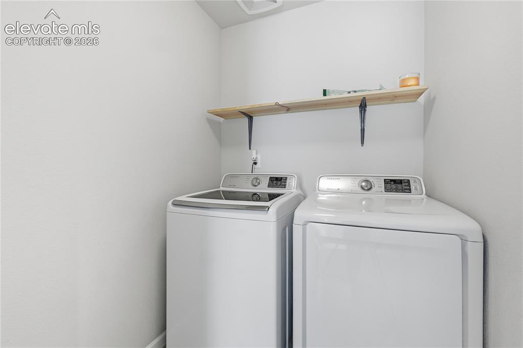 Image 34 of 42: Dedicated laundry area with a top-load washer and front-load dryer