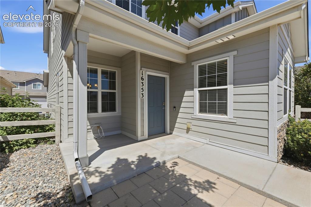 Image 35 of 42: Inviting covered porch with a slate blue entry door