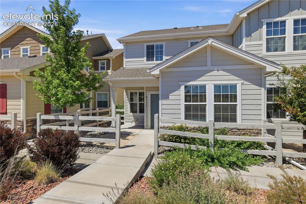 Image 39 of 42: Two-story townhome featuring light gray horizontal siding and white trim