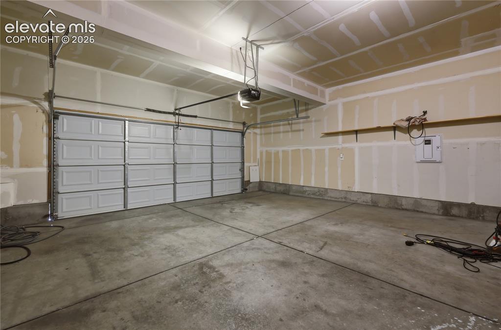 Image 40 of 42: Spacious garage featuring a concrete floor, overhead lighting, an automatic