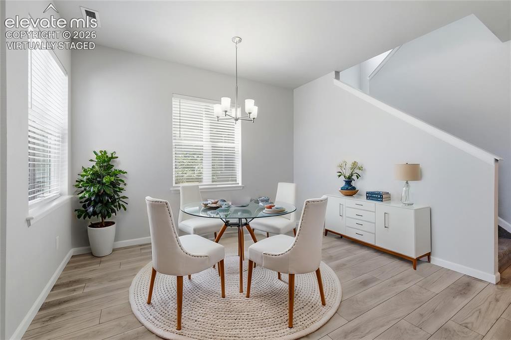 Image 9 of 42: Open-concept dining area featuring wood-finish flooring and multiple window