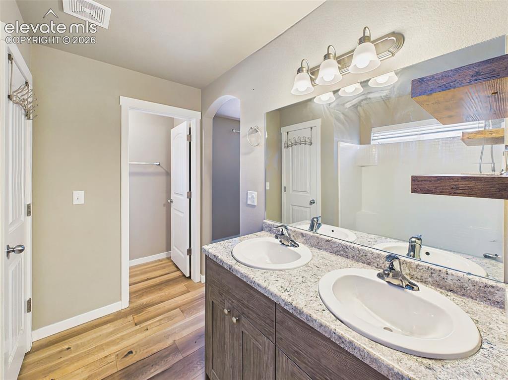 Image 23 of 40: Primary suite featuring a dual-sink vanity, oversized walk-in closet, and o