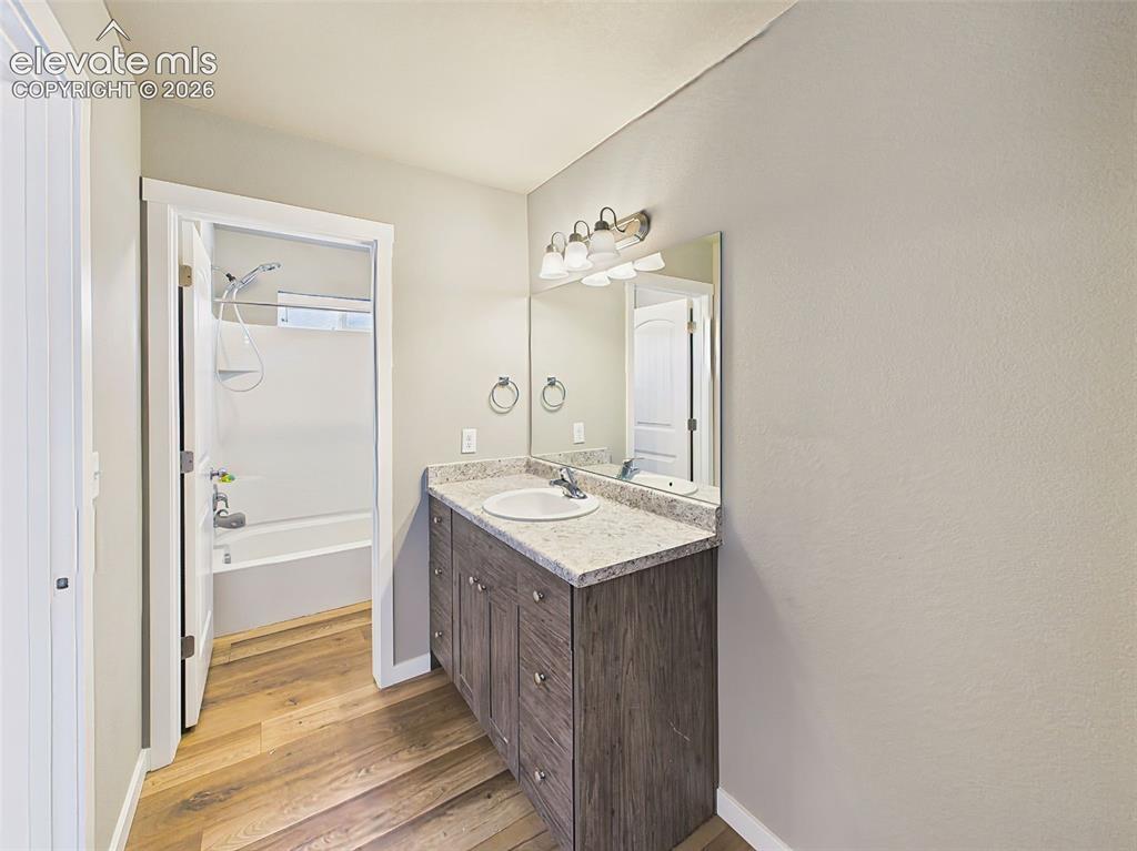 Image 29 of 40: Full bathroom featuring a vanity with storage, formica countertops, and con