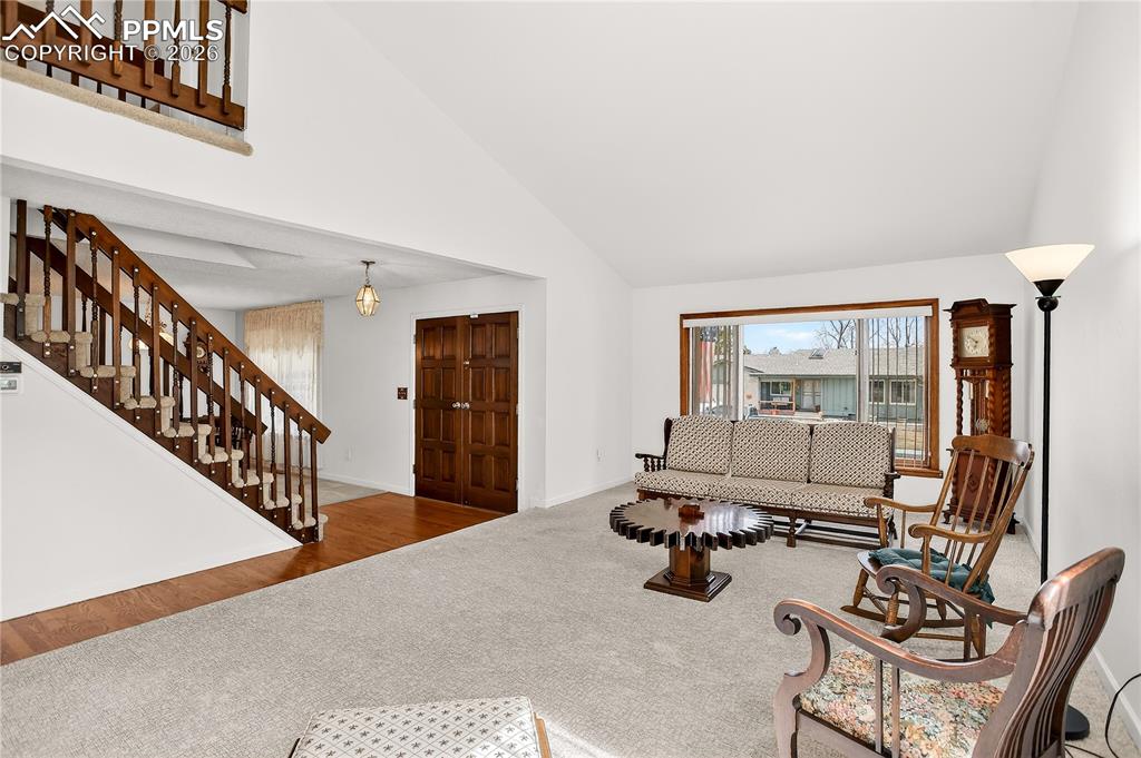 Image 5 of 37: Front entry leads to a large living room with vaulted ceilings