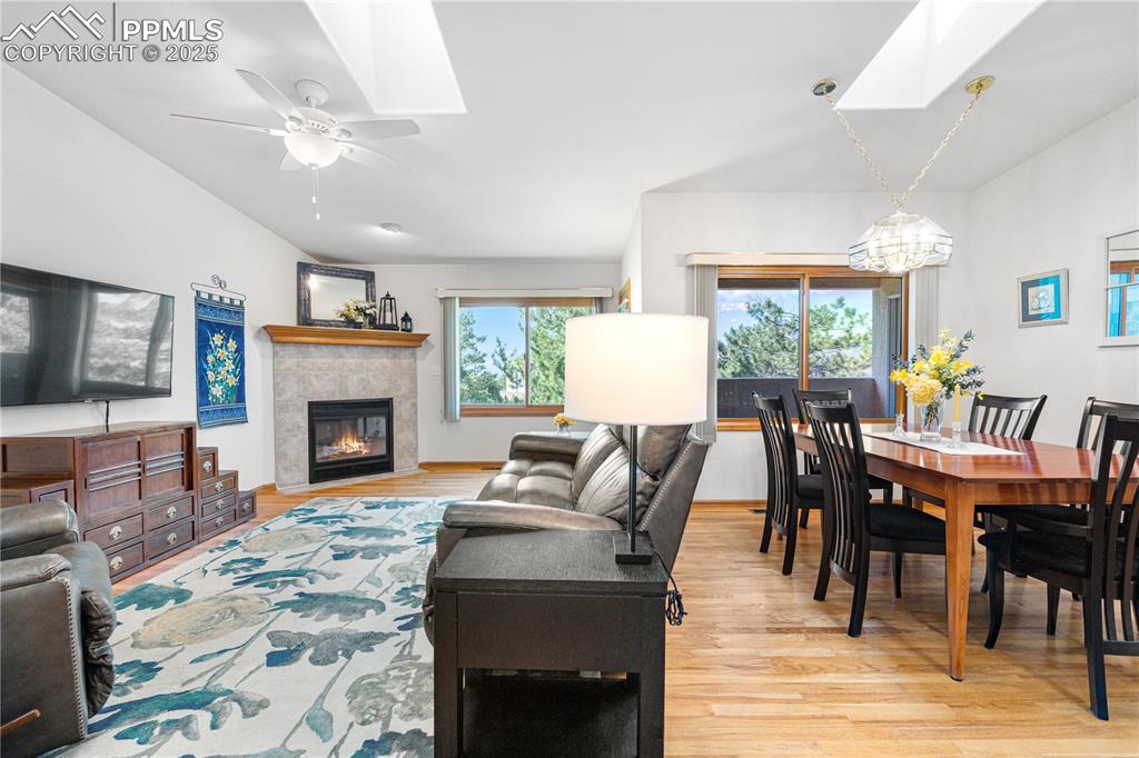 Image 11 of 49: Living area with a skylight, wood finished floors, a chandelier, a tiled fi