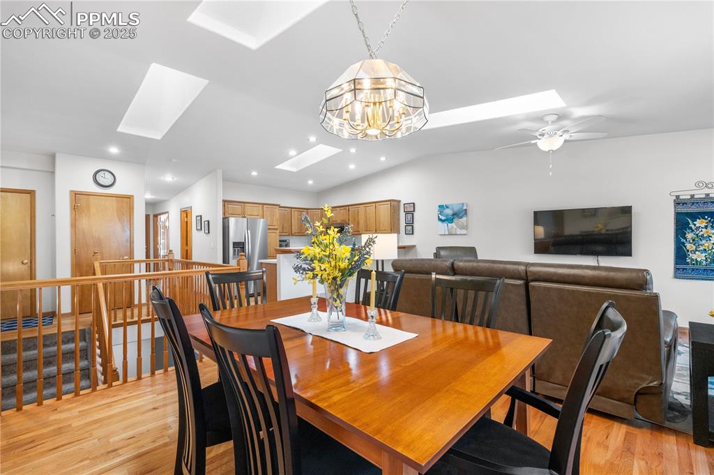 Image 13 of 49: Dining space with a skylight, light wood-style flooring, recessed lighting,