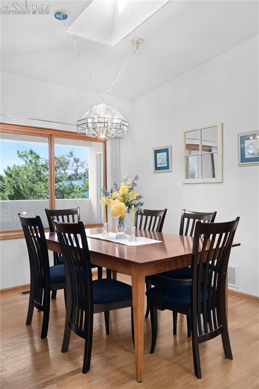 Image 14 of 49: Dining space featuring a chandelier and light wood finished floors